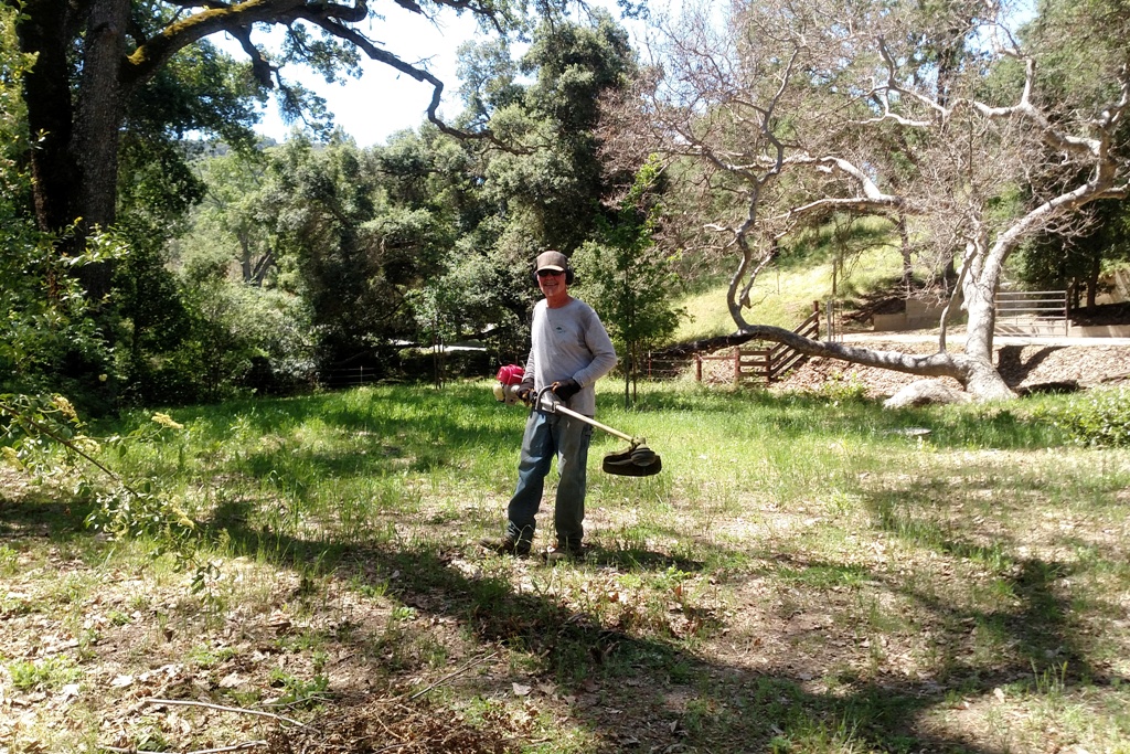 Pat weed-eating the trailhead.